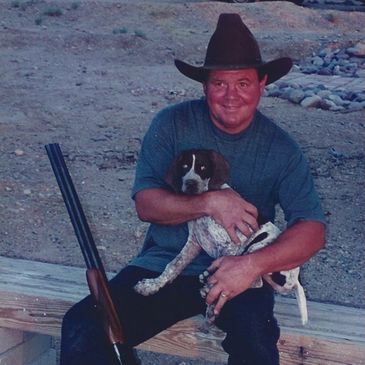 hunter with quail hunting german shorthaired pointer and shotgun.