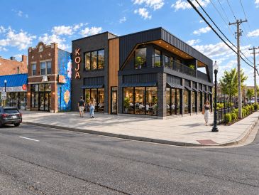 Modern restaurant named KOJA on a sunny street corner.