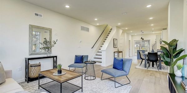 Modern open living room with dining area and staircase.