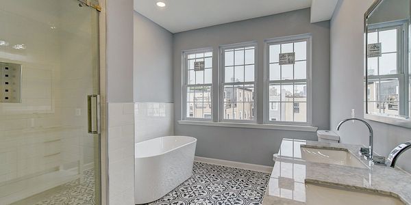Modern bathroom with freestanding tub and patterned floor.