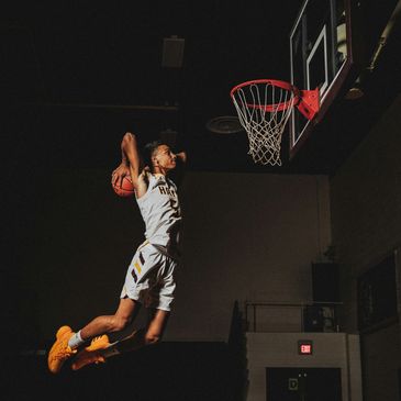 Basketball player in mid-air preparing to dunk the ball.