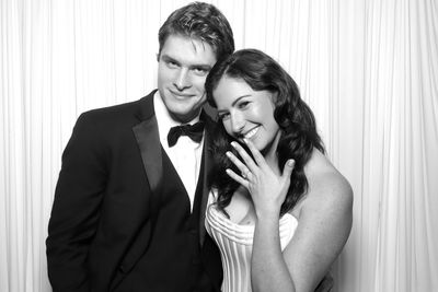 Couple smiling, showing engagement ring.