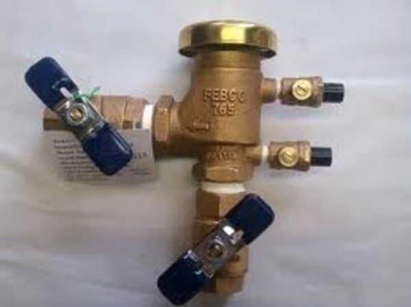 Brass valve assembly with blue handles and pressure gauge fitting.
