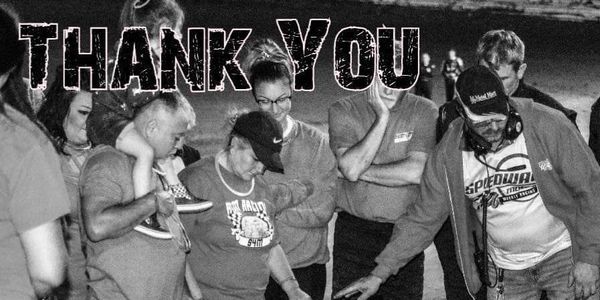 Group of people gathered with 'THANK YOU' text above them in black and white.