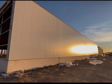 Sunset reflects on a large industrial building under construction.