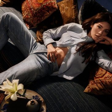 Gracie abrams lying down against pillows