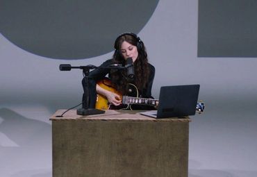 Gracie Abrams playing the guitar