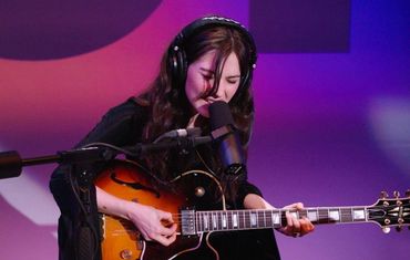 Gracie Abrams playing the guitar