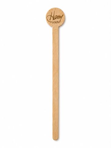 A wooden stir stick with a round top engraved with 'Harry Sasson'.