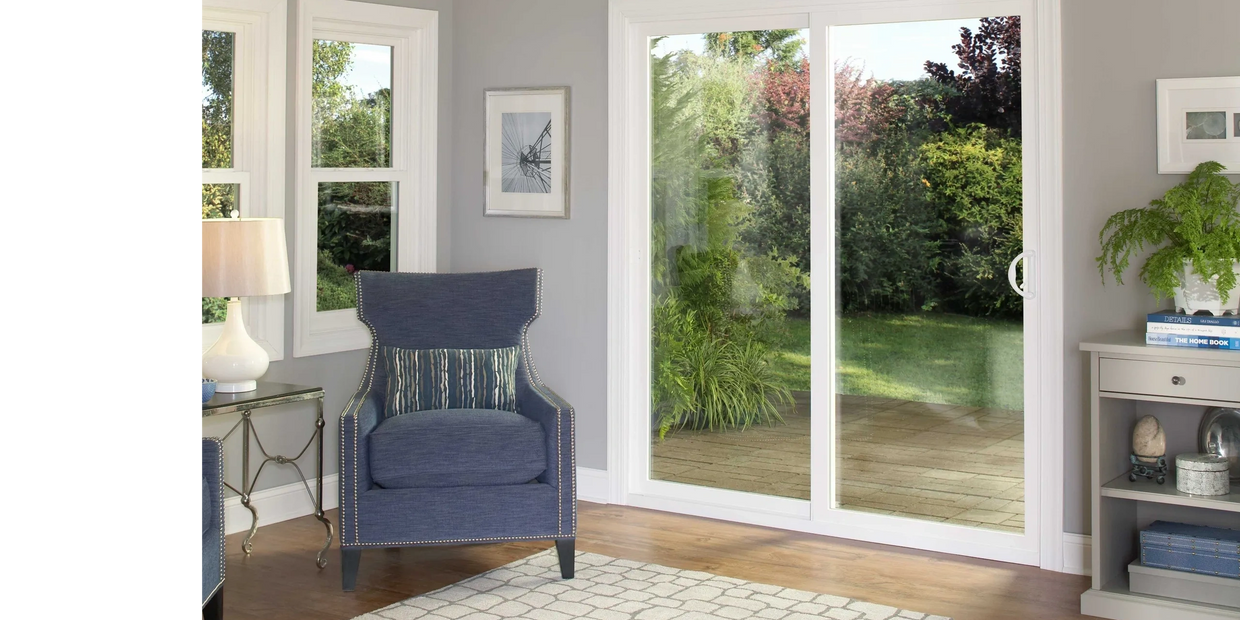 Cozy living room with blue armchair and sliding glass doors to garden.
