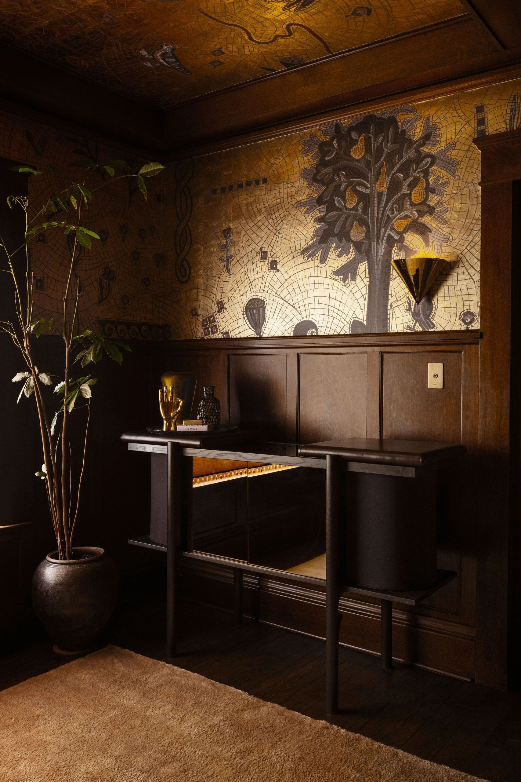 Cozy corner with dark wood paneling and golden mural lighting.