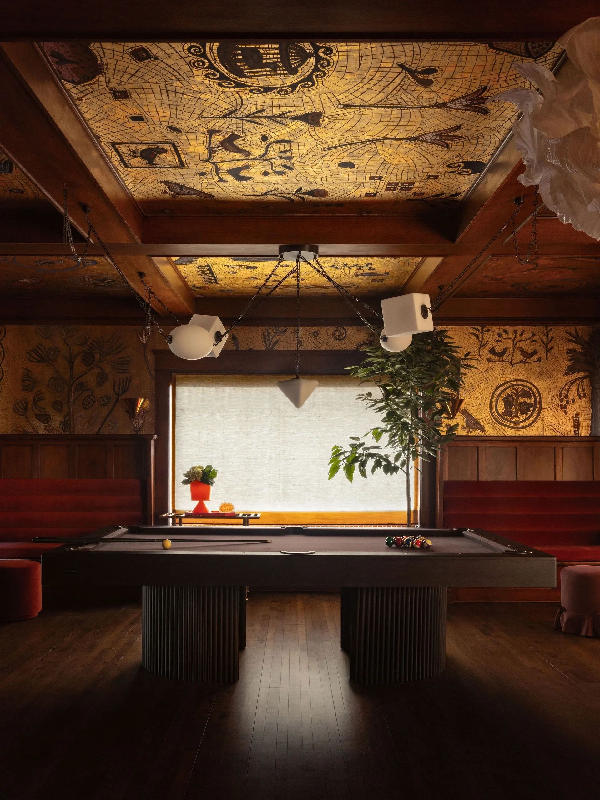 Elegant billiards room with artistic ceiling and warm lighting.