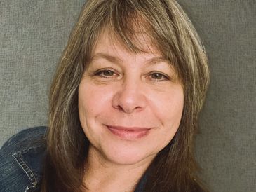 Woman with brown hair smiling gently.