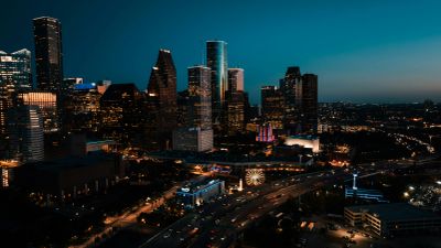 City skyline illuminated at night with busy traffic below.