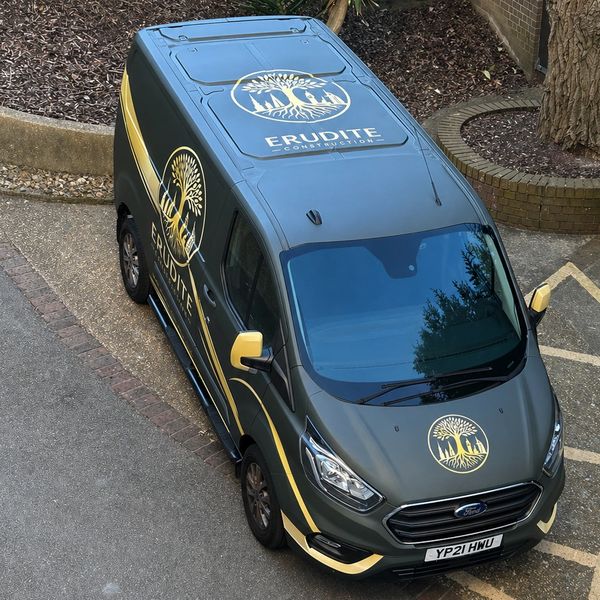 A dark green van with yellow accents and Erudite Construction logo parked outdoors.