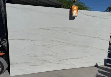 Large white marble slab with subtle gray veining outdoors.