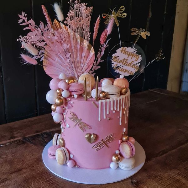 pink dried flowers cake with macarons balls dried flowers and dragonflies pink white and gold