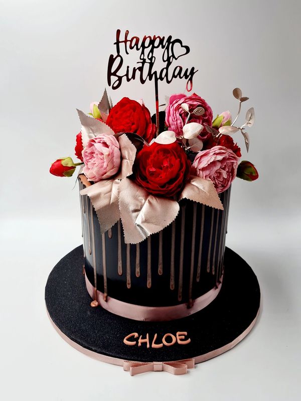 black and rose gold drip cake with silk roses