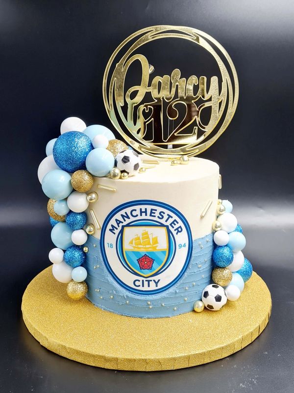man city cake with blue gold and white balls and acrylic topper