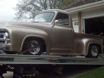 Classic vintage pickup truck on a flatbed tow truck.