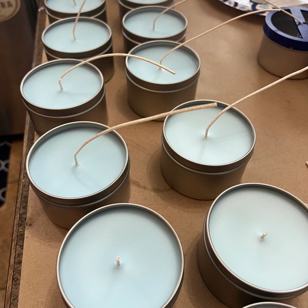 Blue candles in metal tins arranged on a table.