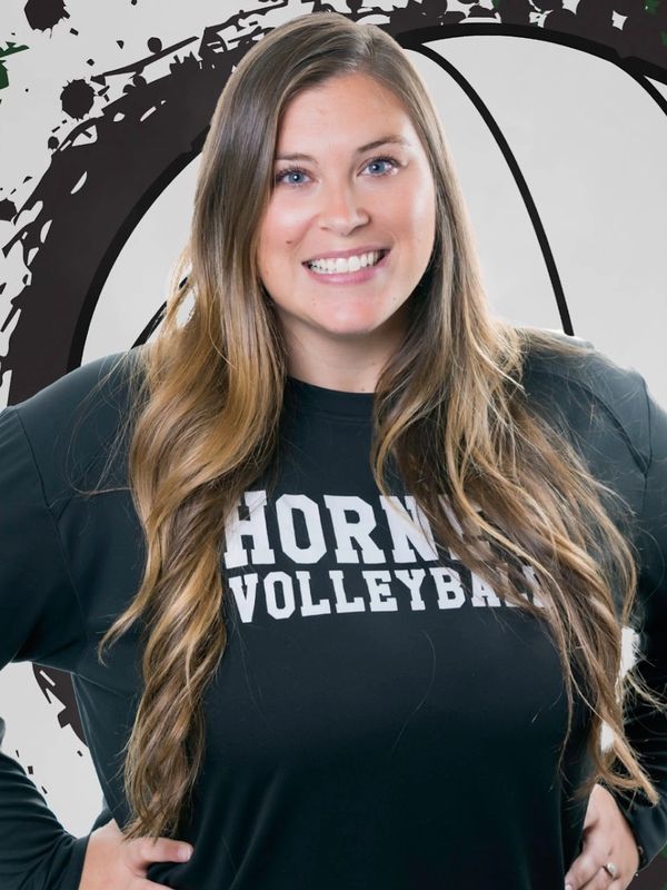 Smiling woman in a "Horn Volleyball" shirt with long wavy hair.