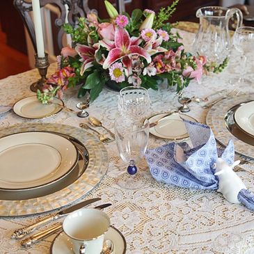 Elegant dining table set with floral centerpiece and fine china.