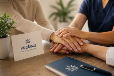 People holding hands in support at a Vitalmás table.