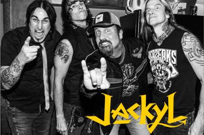 Black and white photo of a rock band named Jackyl posing energetically.