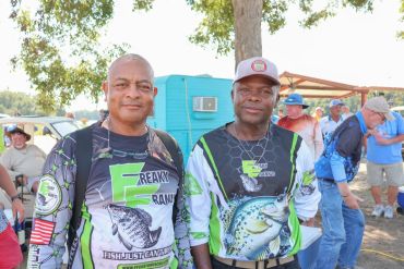 Two men in fishing shirts posing outdoors.