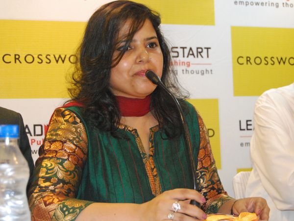Woman speaking at a microphone during an event.