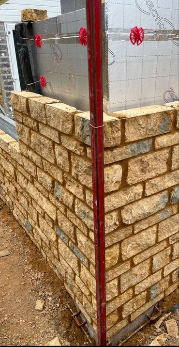 Stone wall in progress on new build house.