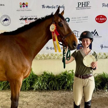 Young equestrian proudly posing with her award-winning horse and ribbon.