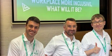 Three men at a workplace training event promoting inclusivity, smiling and giving thumbs up.
