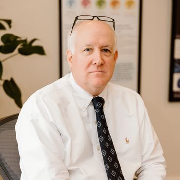 Professional man in white shirt and tie sitting in an office.