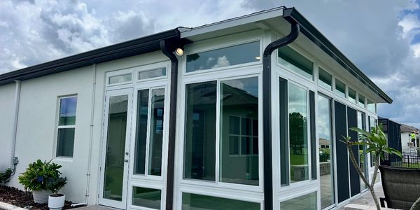 Modern sunroom extension with large glass windows and white frames.