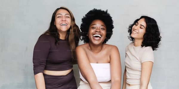 Three diverse, healthy women smiling together, representing community, vitality, and personalized wo