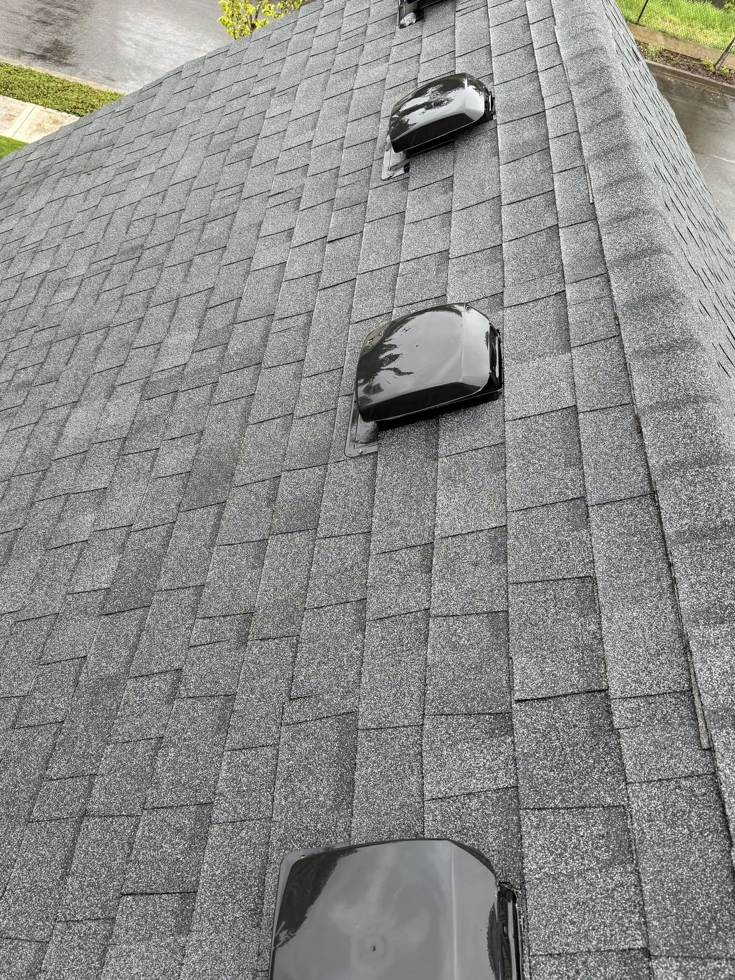 Shingled roof with three black roof vents.