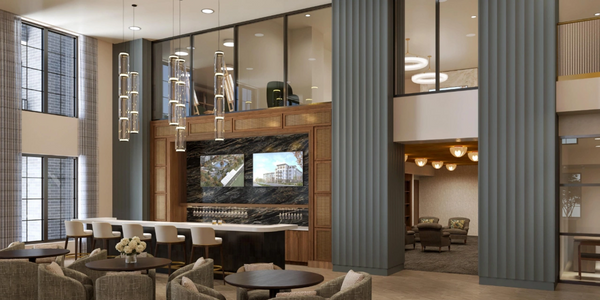 Modern lounge area with bar seating, round tables, and pendant lights.