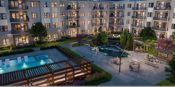 Modern apartment complex with illuminated pool and courtyard at dusk.