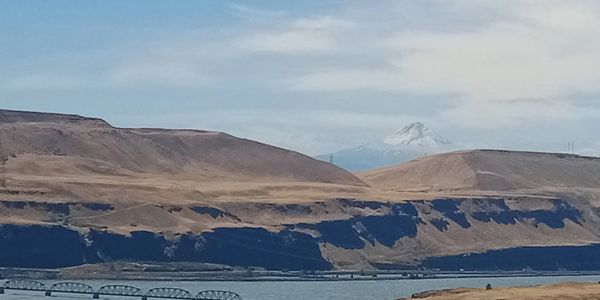 Mountain and river with bridge in a dry landscape.