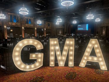 Illuminated GMA letters in a grand hall.
