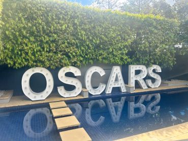 Large OSCARS letters by a pool.