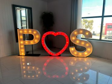 Illuminated letters P, heart, and S with reflections.