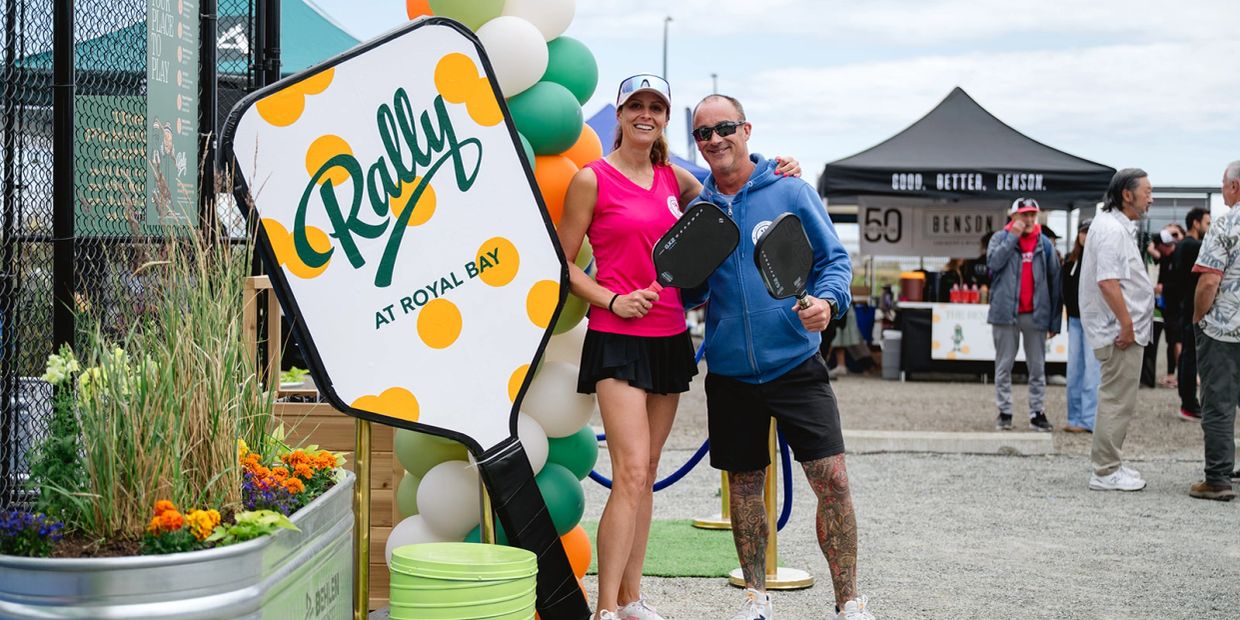 Two people holding pickleball paddles at Rally event.