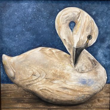 Wooden antique duck decoy with patina of age and historic wear is painted against a cool blue textur