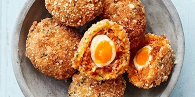 Scotch eggs with a crispy coating and soft yolk inside.