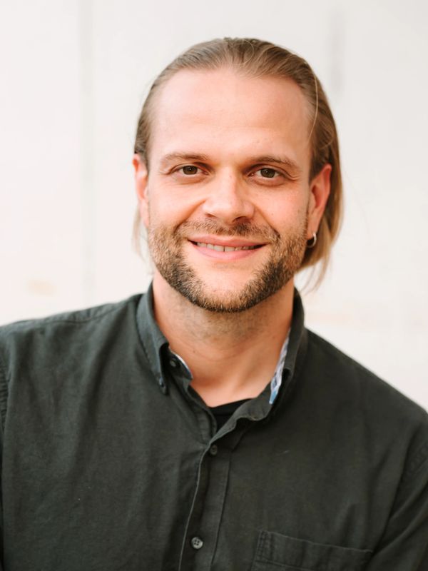 Smiling man with beard and long hair.