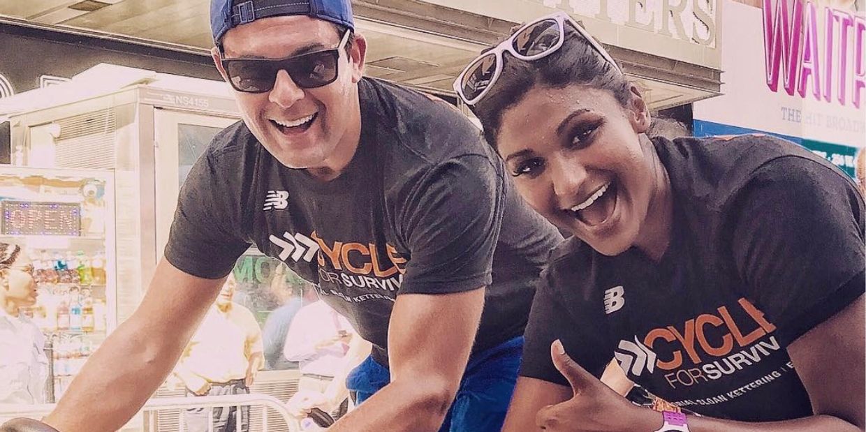 Two people smiling and posing at a cycling event for charity.
