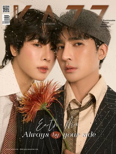 Two stylish men posing closely with a flower on a magazine cover.